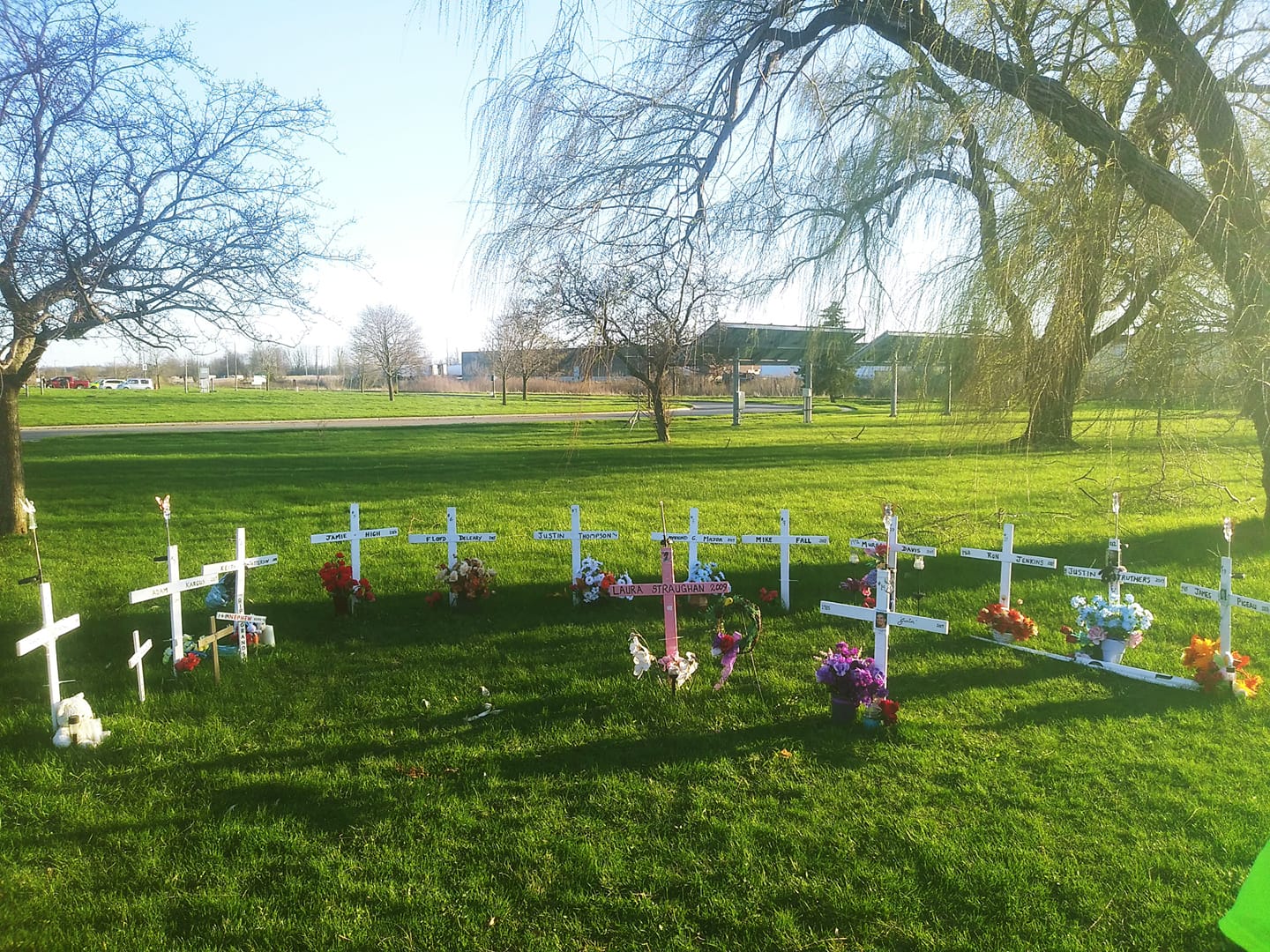 Photo shows series of white and pink crosses lined up in semi circles representing lives of those lost at EMDC. 